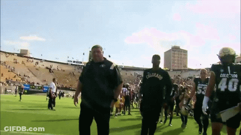 A Man Wearing A Colorado Shirt Walks With A Group Of Football Players GIF