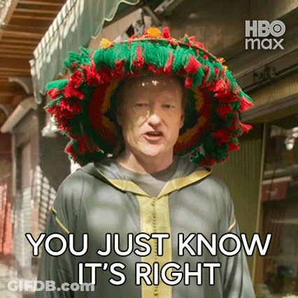 A Man Wearing A Colorful Hat Is Standing In Front Of A Building And Says `` You Just Know It 'S Right '' . GIF