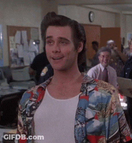 A Man Wearing A Colorful Shirt And A White Shirt Is Smiling In An Office GIF