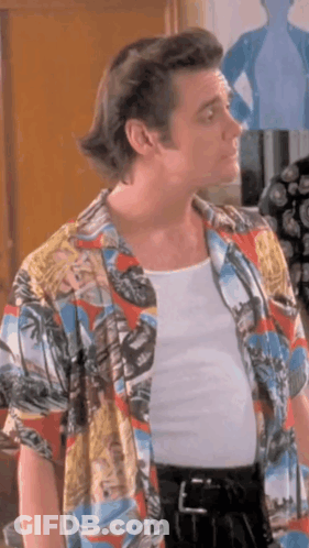 A Man Wearing A Colorful Shirt And A White Tank Top . GIF