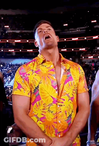 A Man Wearing A Colorful Shirt Is Standing In Front Of A Crowd In A Stadium . GIF