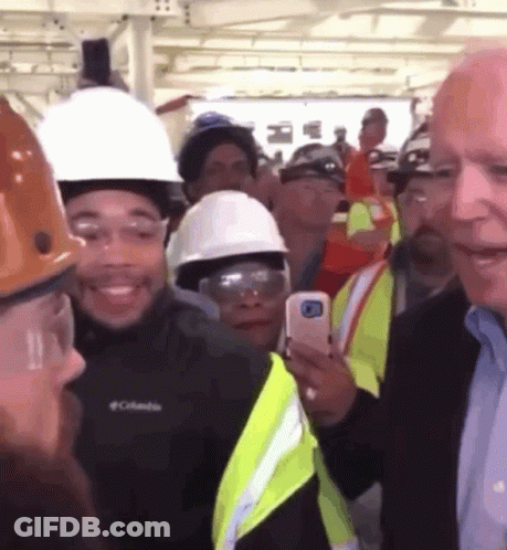 A Man Wearing A Columbia Jacket Stands In A Crowd GIF