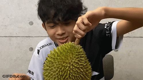 A Man Wearing A Corsair Shirt Is Eating A Durian GIF