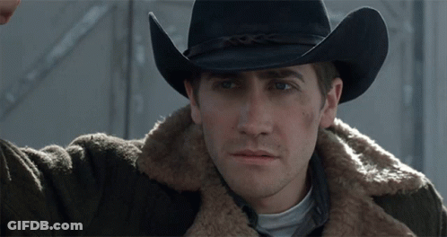 A Man Wearing A Cowboy Hat And A Brown Jacket GIF