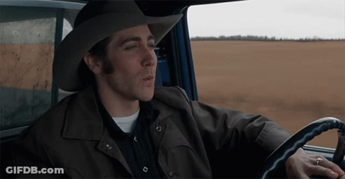 A Man Wearing A Cowboy Hat And A Leather Jacket Is Driving A Car GIF