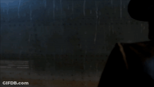 A Man Wearing A Cowboy Hat And A Leather Jacket Stands In The Rain GIF
