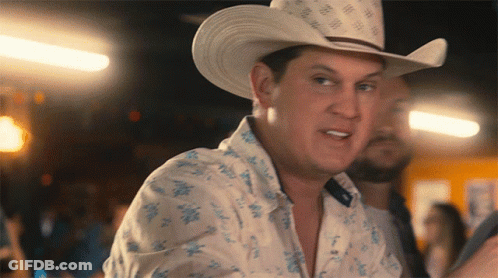 A Man Wearing A Cowboy Hat And A Shirt With Flowers On It GIF