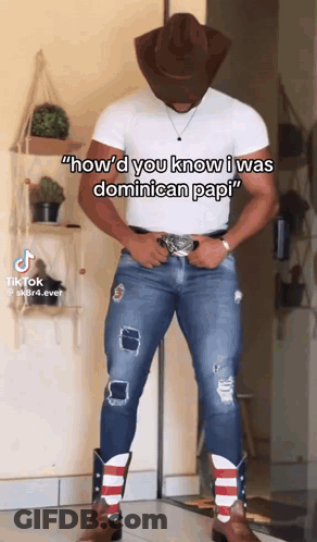 A Man Wearing A Cowboy Hat And Cowboy Boots Is Standing In Front Of A Wall . GIF