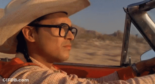 A Man Wearing A Cowboy Hat And Glasses Driving A Car GIF