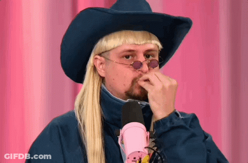 A Man Wearing A Cowboy Hat And Sunglasses Holds His Hand To His Nose GIF