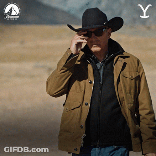 A Man Wearing A Cowboy Hat And Sunglasses Talks On A Cell Phone GIF