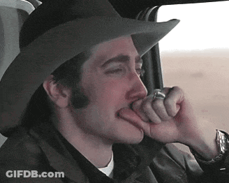A Man Wearing A Cowboy Hat Is Biting His Finger GIF