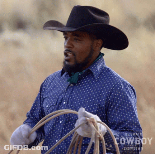 A Man Wearing A Cowboy Hat Is Holding A Lasso In His Hands GIF