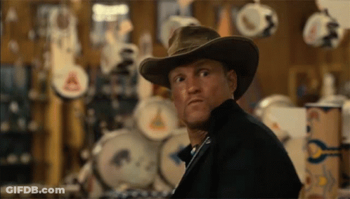 A Man Wearing A Cowboy Hat Is Looking At Something GIF