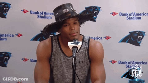 A Man Wearing A Cowboy Hat Stands In Front Of A Bank Of America Banner GIF