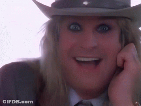 A Man Wearing A Cowboy Hat With His Tongue Out GIF