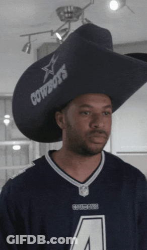 A Man Wearing A Cowboys Jersey And A Large Hat GIF