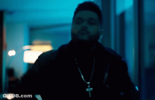 A Man Wearing A Cross Necklace And A Black Jacket GIF