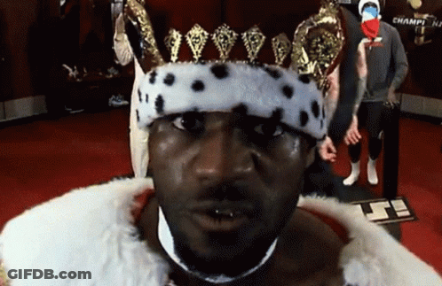 A Man Wearing A Crown And A Fur Coat Is Standing In Front Of A Sign That Says Champi GIF