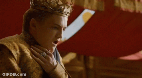A Man Wearing A Crown And A Gold Robe Is Standing Next To A Woman In A Room . GIF