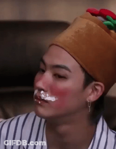 A Man Wearing A Crown And A Striped Shirt Has Icing On His Face And Nose . GIF