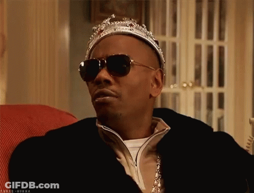 A Man Wearing A Crown And Sunglasses Is Sitting In A Chair GIF