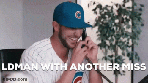 A Man Wearing A Cubs Hat Is Talking On A Phone While Smiling . GIF