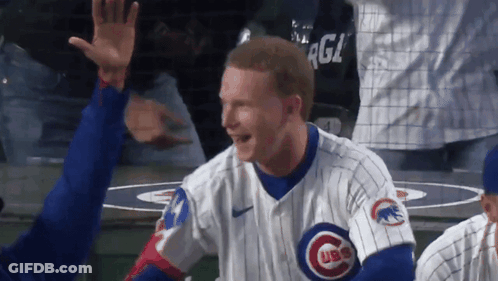 A Man Wearing A Cubs Jersey High Fives Another Player GIF