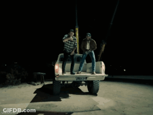 A Man Wearing A Dallas Hat Is Laughing While Sitting Next To Another Man GIF