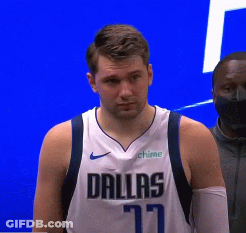 A Man Wearing A Dallas Jersey Is Standing In Front Of A Blue Wall . GIF