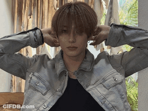 Man In Denim Jacket And Black Shirt With Hands On Head GIF