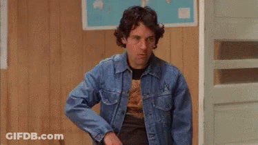 A Man Wearing A Denim Jacket And Sunglasses Is Standing In A Room . GIF