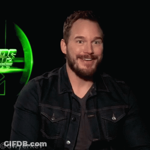 A Man Wearing A Denim Jacket Is Laughing In Front Of A Star Wars Sign GIF