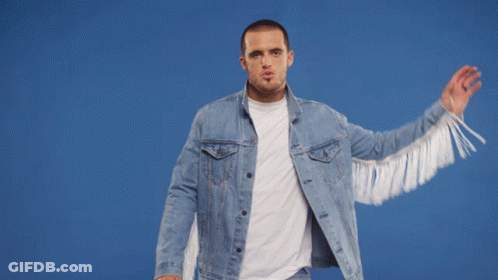 A Man Wearing A Denim Jacket With White Fringe GIF