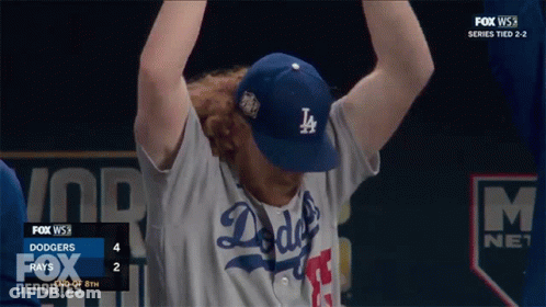 A Man Wearing A Dodgers Hat Holds His Arms Up GIF