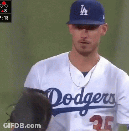 A Man Wearing A Dodgers Jersey Is Standing On A Baseball Field GIF