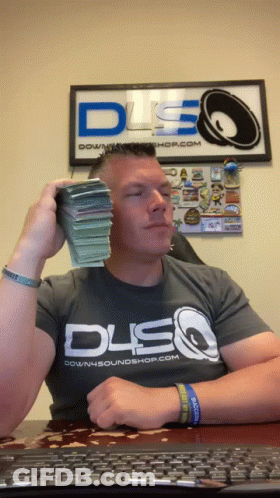 A Man Wearing A Downsoundshop.com Shirt Is Holding A Stack Of Money In Front Of His Face GIF