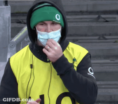 A Man Wearing A Face Mask And A Green Hat With The Number 0 On It GIF