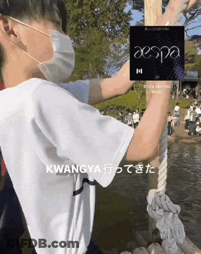 A Man Wearing A Face Mask Holds Onto A Rope With A Aespa Logo On It GIF