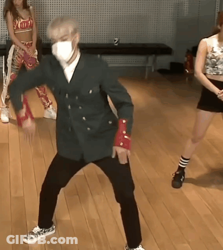 A Man Wearing A Face Mask Is Dancing On A Wood Floor GIF