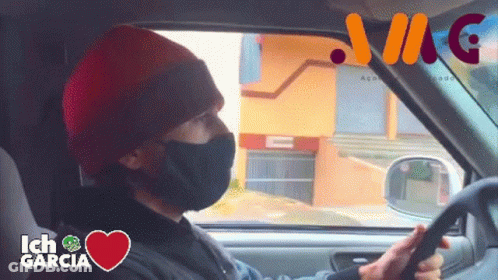 A Man Wearing A Face Mask Is Driving A Car With Ich Garcia Written In The Corner GIF