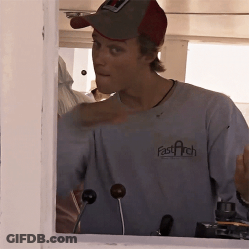 A Man Wearing A Fast Arch T-Shirt Looks Out Of A Window GIF
