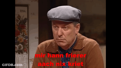 A Man Wearing A Flat Cap And A Brown Jacket Says Mir Hann Frierer Aach Mix Riet GIF