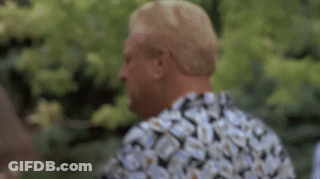A Man Wearing A Floral Shirt Is Standing In Front Of A Tree . GIF