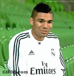 A Man Wearing A Fly Emirates Jersey Is Sitting On A Green Chair . GIF