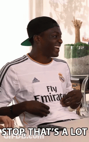 A Man Wearing A Fly Emirates Jersey Is Smiling GIF