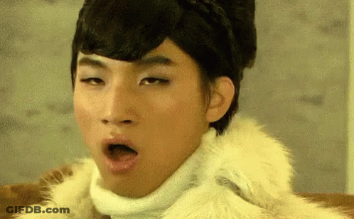 A Man Wearing A Fur Coat And A White Turtleneck Is Making A Funny Face GIF