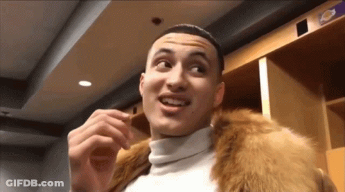 A Man Wearing A Fur Coat And A White Turtleneck Is Standing In A Locker Room GIF