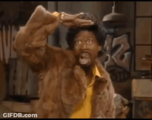 A Man Wearing A Fur Coat And A Yellow Shirt Is Making A Funny Face GIF