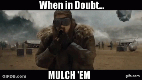 A Man Wearing A Fur Coat And Goggles Is Holding A Gun With The Words When In Doubt Mulch 'Em Below Him GIF